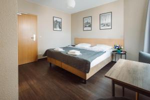 a bedroom with a bed and a table in a room at Happy Hotel Berlin in Berlin