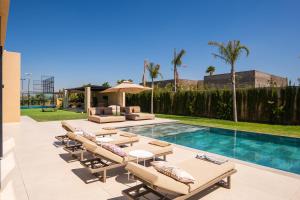 a patio with lounge chairs and a swimming pool at Villa prestige, terrain padel, salle de sport, hammam in Aït Amara el Ouled