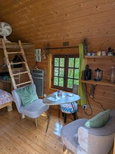 a living room with a table and chairs in a cabin at La bulle des champs in Champmotteux