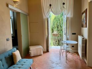 a living room with a blue couch and a table and a window at Il Torchio - Guest House Lago Maggiore in Dormelletto