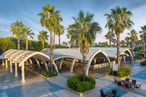 a view of a building with palm trees and tables at Susesi Luxury Resort in Belek