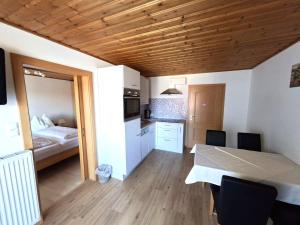 a kitchen and dining room with a table and a bed at Pension Waldhof in Koppl