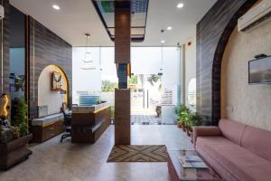 a living room with a pink couch and some plants at Hotel Pravasa Stay, Dewas Naka in Indore