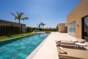 a swimming pool in the backyard of a house at Villa prestige, terrain padel, salle de sport, hammam in Aït Amara el Ouled