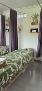a bedroom with two beds and purple curtains at Medewi Manor in Pulukan +60 photos