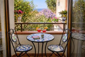 a table with two chairs and two glasses on a balcony at Stella Marina Sea & Sun in Cefalù