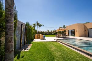 a backyard of a house with a swimming pool at Villa prestige, terrain padel, salle de sport, hammam in Aït Amara el Ouled