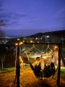 a couple of people sleeping in hammocks at night at Căsuța de pe Vale in Sighetu Marmaţiei +56 photos