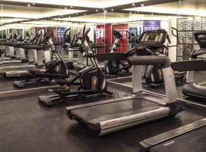 une salle de sport avec plusieurs rangées d'appareils de cardio-training dans l'établissement Hotel Francia Aguascalientes, à Aguascalientes