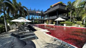 a building with a swimming pool with chairs and umbrellas at Rosso Sky Villa Phu Quoc in Phú Quốc