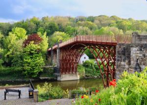 a bridge over a river next to a river at Charming 3 Bedroom High St Apartment in Much Wenlock