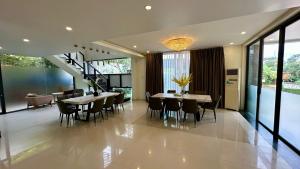 a dining room with tables and chairs and a staircase at Rosso Sky Villa Phu Quoc in Phú Quốc