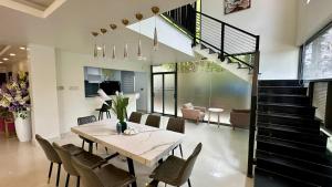 a dining room with a table and chairs and a staircase at Rosso Sky Villa Phu Quoc in Phú Quốc