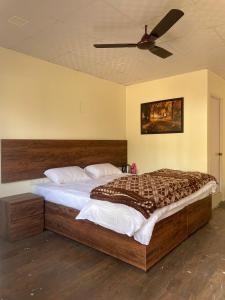 a bedroom with a large bed with a ceiling at The Cottage Depot in Bīr