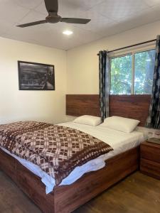 a bedroom with a large bed and a window at The Cottage Depot in Bīr