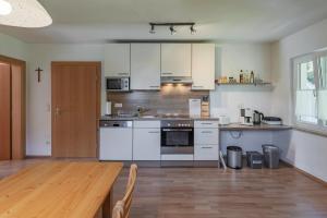 a kitchen with white appliances and a wooden table at Ferienwohnung Regentalblick in Miltach +24 photos