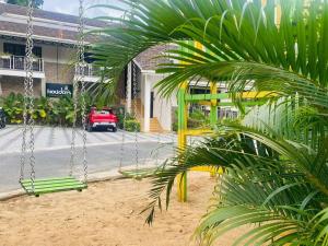a swing with a red car parked in front of a building at Holidays Garden Resort in Kalpetta