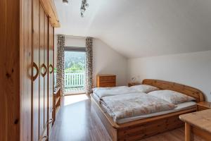 a bedroom with a large bed and a window at Ferienwohnung Regentalblick in Miltach