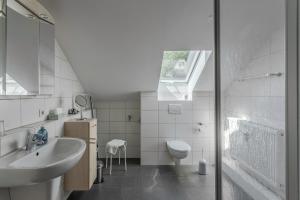 a white bathroom with a sink and a toilet at Ferienwohnung Regentalblick in Miltach