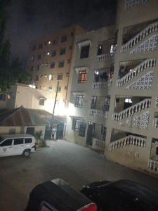 a parking lot in front of a building at night at Murangiri Accommodations Mahnoor in Mombasa
