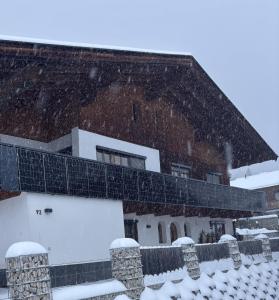 a building with snow on the roof at Ferienwohnung Schmiedhofer in Ellmau
