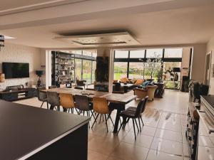 a kitchen and living room with a table and chairs at Villa du Siéck bord de mer piscine 14 P in Santec