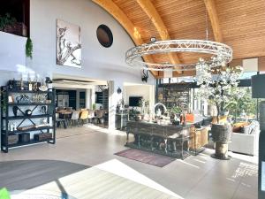 a living room with a chandelier and a table at Villa du Siéck bord de mer piscine 14 P in Santec