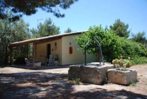 ein kleines Haus mit einem Brunnen davor in der Unterkunft Terrauzza Sul Mare di Renata Emmolo in Syrakus
