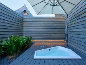a bath tub on a wooden deck with an umbrella at LANDFORM workshop cottage KEIHOKU in Kyoto