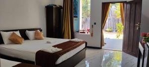 a bedroom with a bed and a sliding glass door at Calm Night Surf Stay in Arugam Bay