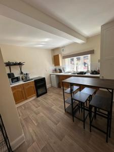 a kitchen with a table and chairs in a room at Charming 3 Bedroom High St Apartment in Much Wenlock