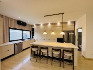 a kitchen with a large island with bar stools at Villa Sol Aviv - וילה מושלמת עם בריכה פרטית למשפחות וקבוצות בנתיבות in Netivot
