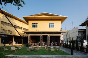 a building with chairs and tables in front of it at Kosin House in Bangkok