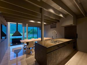 a kitchen with a sink and a counter with a table at LANDFORM workshop cottage KEIHOKU in Kyoto +60 photos