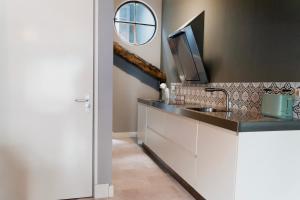 a kitchen with a sink and a mirror at OP ZESTIEN in Hippolytushoef +26 photos