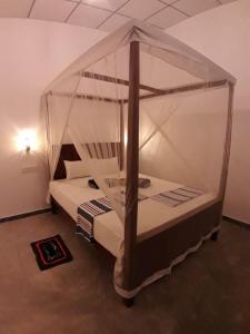 a bedroom with two beds with a canopy at Cashew Villa Hiriketiya in Hiriketiya