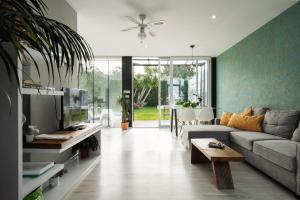 a living room with a couch and a tv at Casa Calima in Esteiro