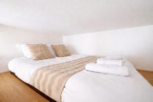 a bedroom with a white bed with towels on it at l'Azur Viennois in Vienne