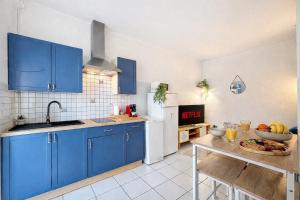 a kitchen with blue cabinets and a table with food on it at l'Azur Viennois in Vienne