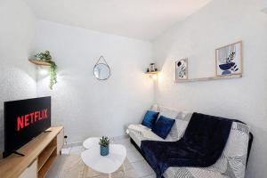 a living room with a couch and a tv at l'Azur Viennois in Vienne