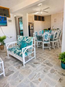 a patio with white chairs and a table and a dining room at Suites Acapulco Real in Acapulco