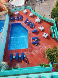 an overhead view of a swimming pool with chairs and tables at Suites Acapulco Real in Acapulco