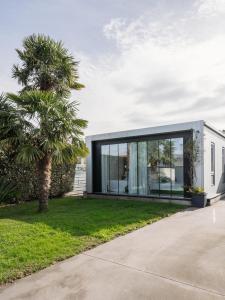 a house with glass doors and a palm tree at Casa Calima in Esteiro