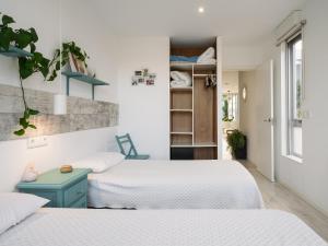 two beds in a small room with white walls at Casa Calima in Esteiro +48 photos