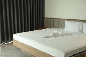 a large white bed with a white robe on it at Achi Ocean Villa in Cửa Lô