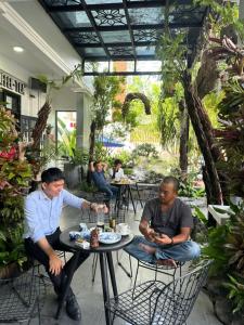 a group of men sitting at tables in a restaurant at Cherry Villa in Hue +23 photos