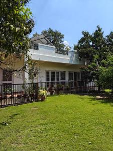 a house with a fence in front of a yard at Chandrakanta farm stay in Lucknow