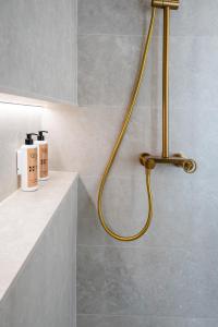 a shower with a yellow hose in a bathroom at Apartamentos 4Duques in Cáceres +175 photos