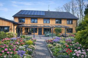 a house with a lot of flowers in front of it at Hotel Ehlers in Schneverdingen