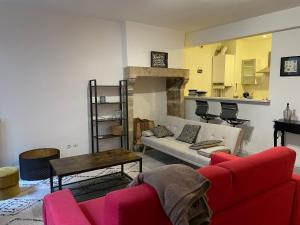 a living room with a red couch and a table at Sand Home in Le Puy-en-Velay